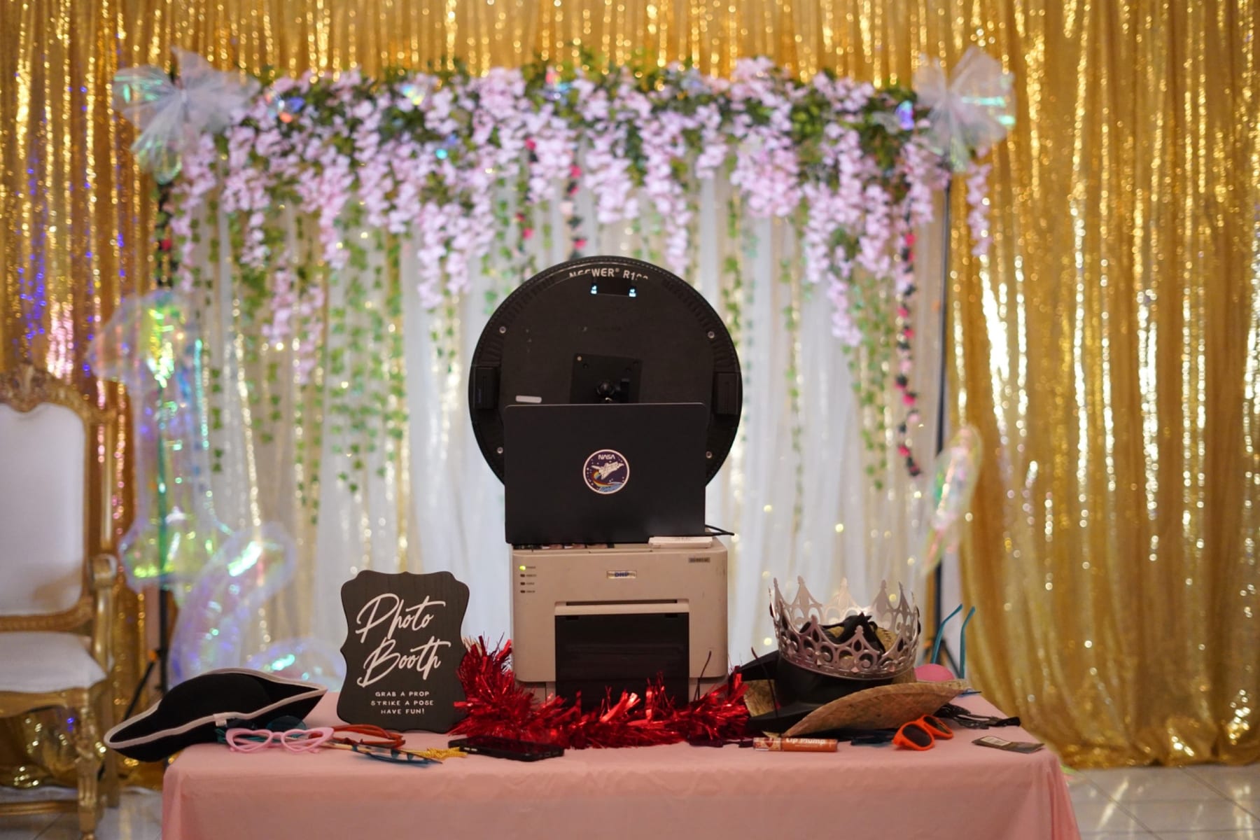 Photo booth with gold backdrop and props